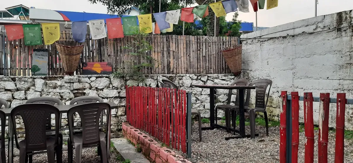 Open-air garden seating with prayer flags at Ching Cafe